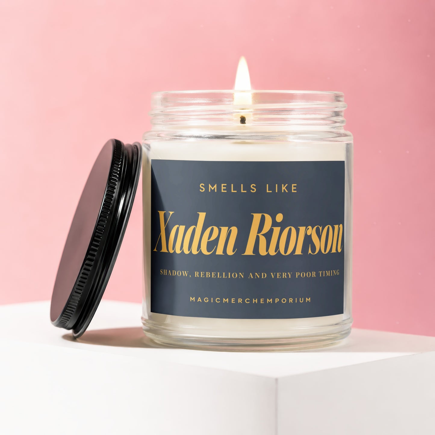 Candle with "Xaden Riorson" and scent description on a pink background.