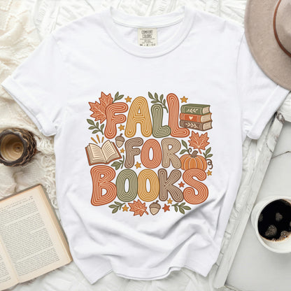 White t-shirt with "Fall for Books" graphic featuring pumpkins, leaves, and books.