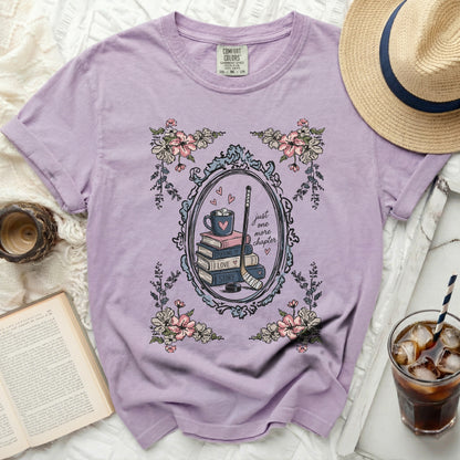 Purple t-shirt with stacked books, hockey stick, and heart graphic.
