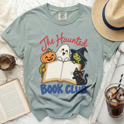 Light blue t-shirt with "The Haunted Book Club" graphic featuring a ghost, pumpkin, witch, and cat.