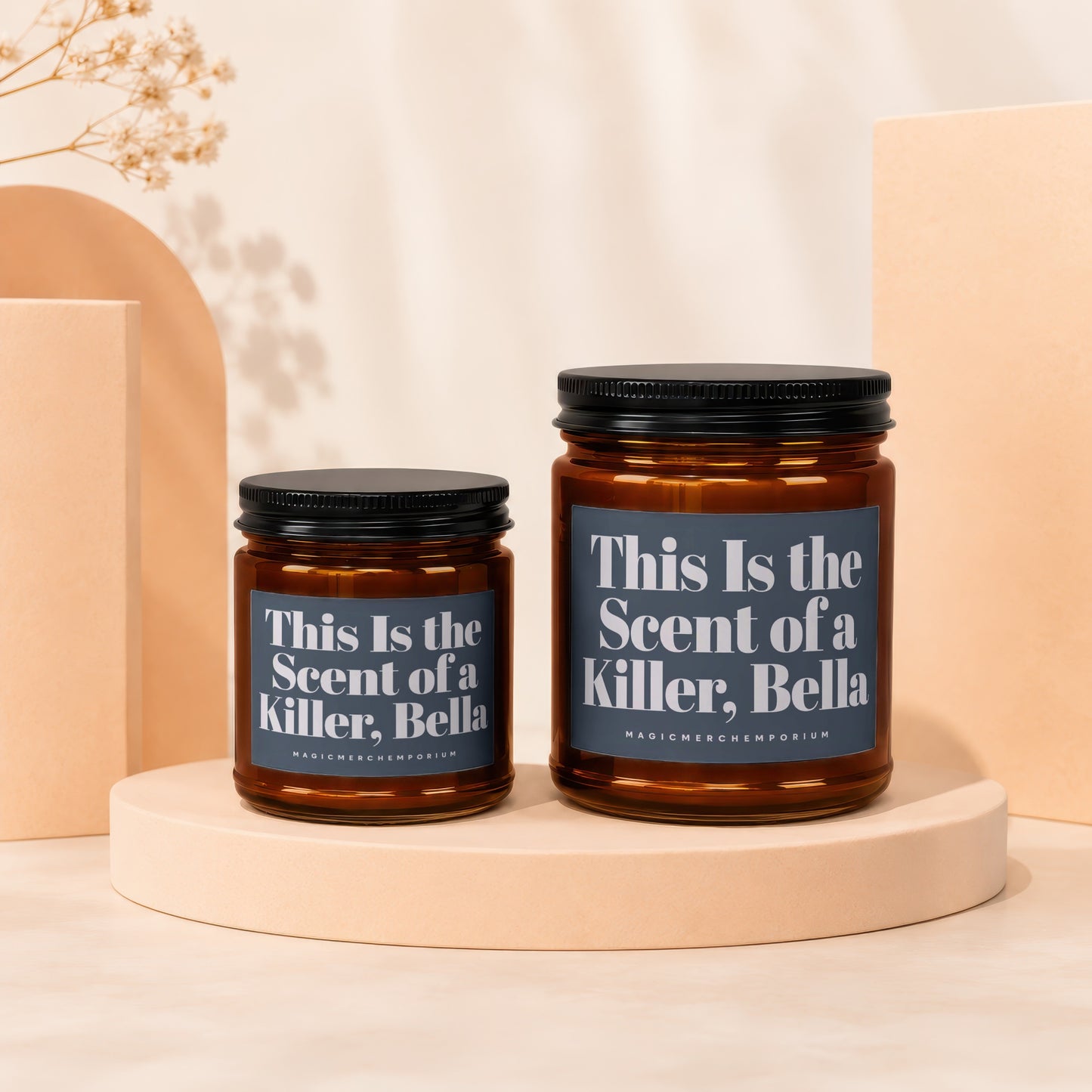 Two amber glass candles with black lids and dark gray labels reading "This Is the Scent of a Killer, Bella".