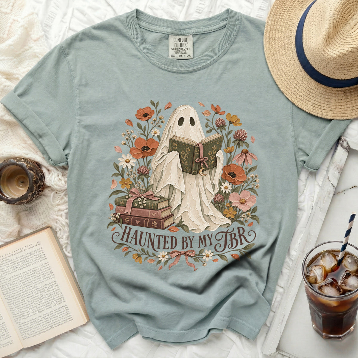Ghost reading book surrounded by flowers and text "Haunted by my TBR".