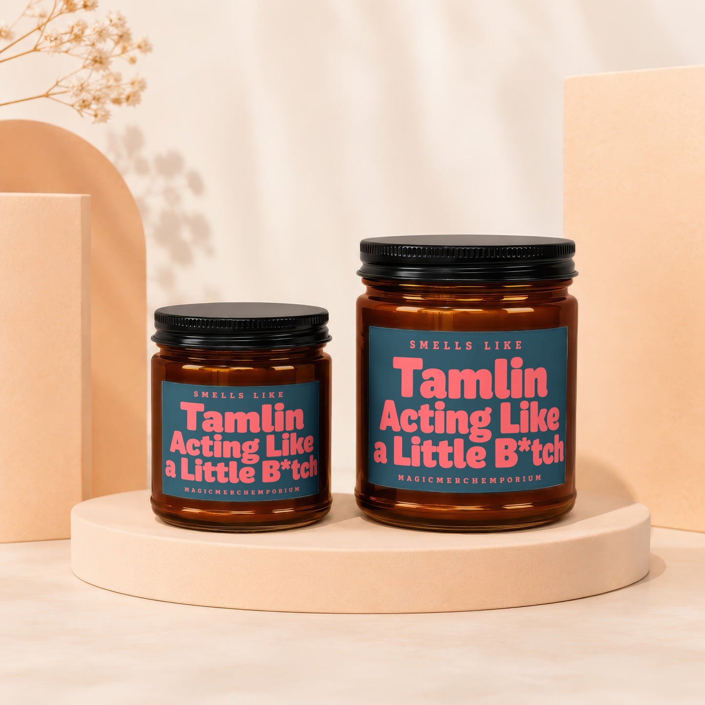 Two amber glass candles with black lids, labeled "Tamlin Acting Like a Little B*tch".