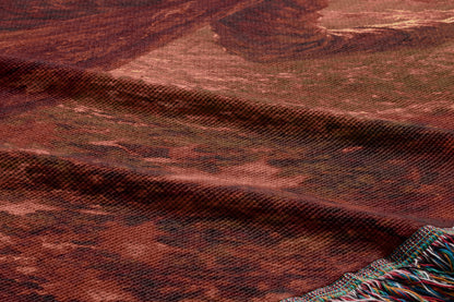a close-up view of a textured fabric with a reddish-brown color and a pattern resembling a mountain or landscape.