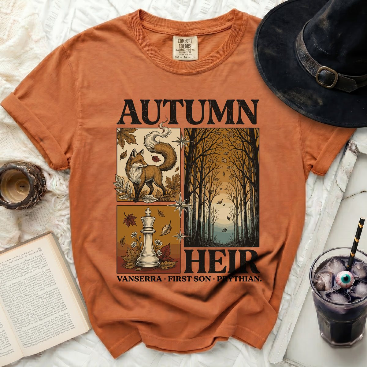 Orange t-shirt with "AUTUMN HEIR" text and forest, fox, and chess king graphics.