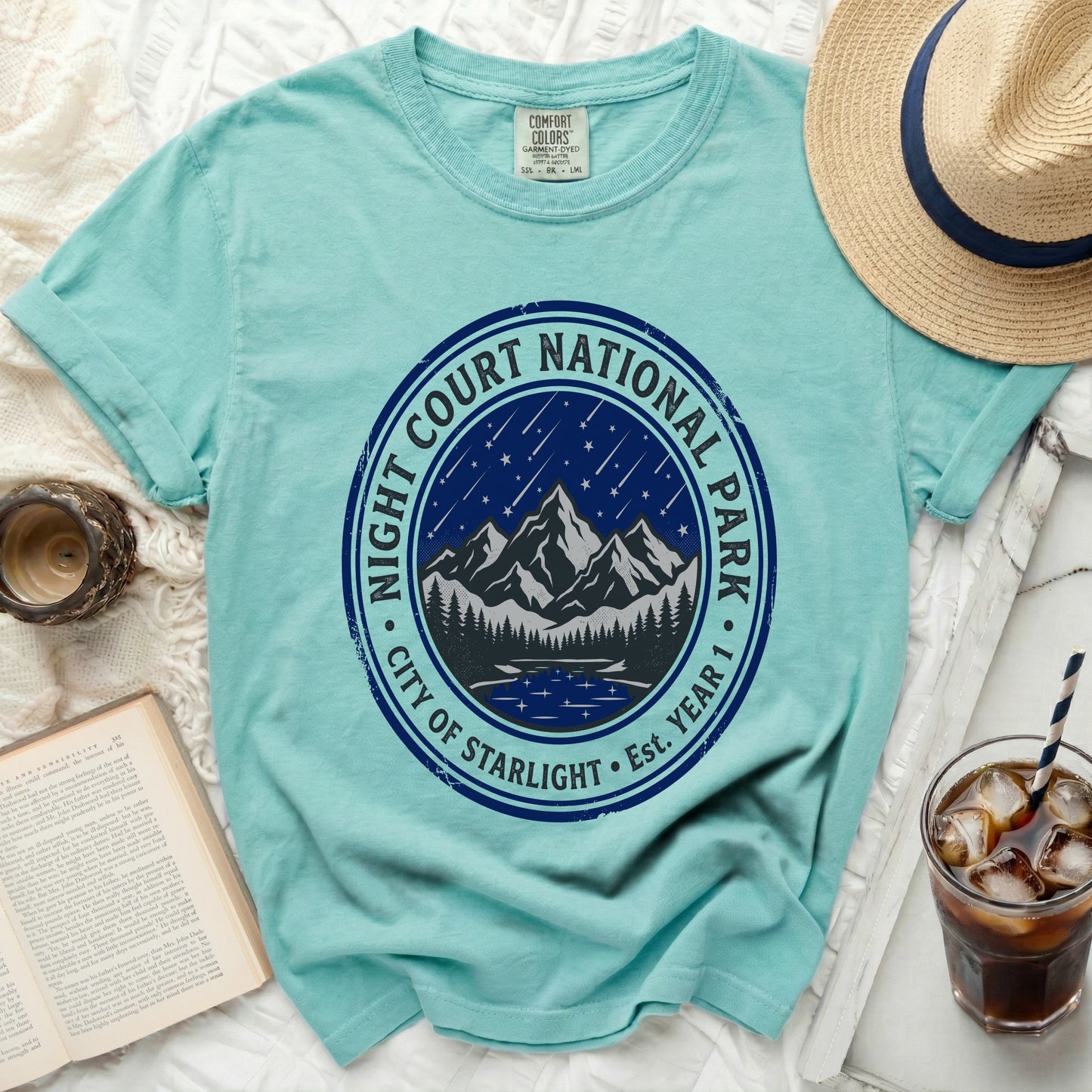 Aqua t-shirt with "Night Court National Park City of Starlight" circular graphic.