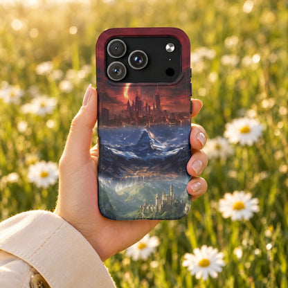 A hand holds a phone case featuring a fantasy landscape of mountains, a castle, and a city against a sunset sky.