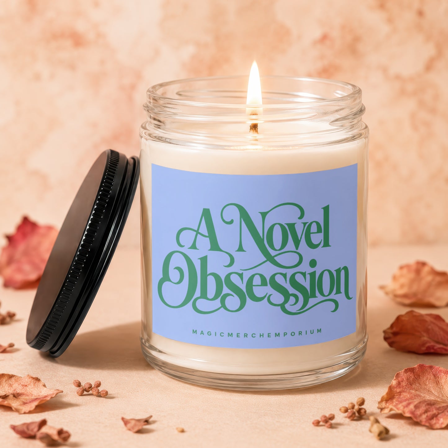 Candle with "A Novel Obsession" text on light blue label, lid askew.