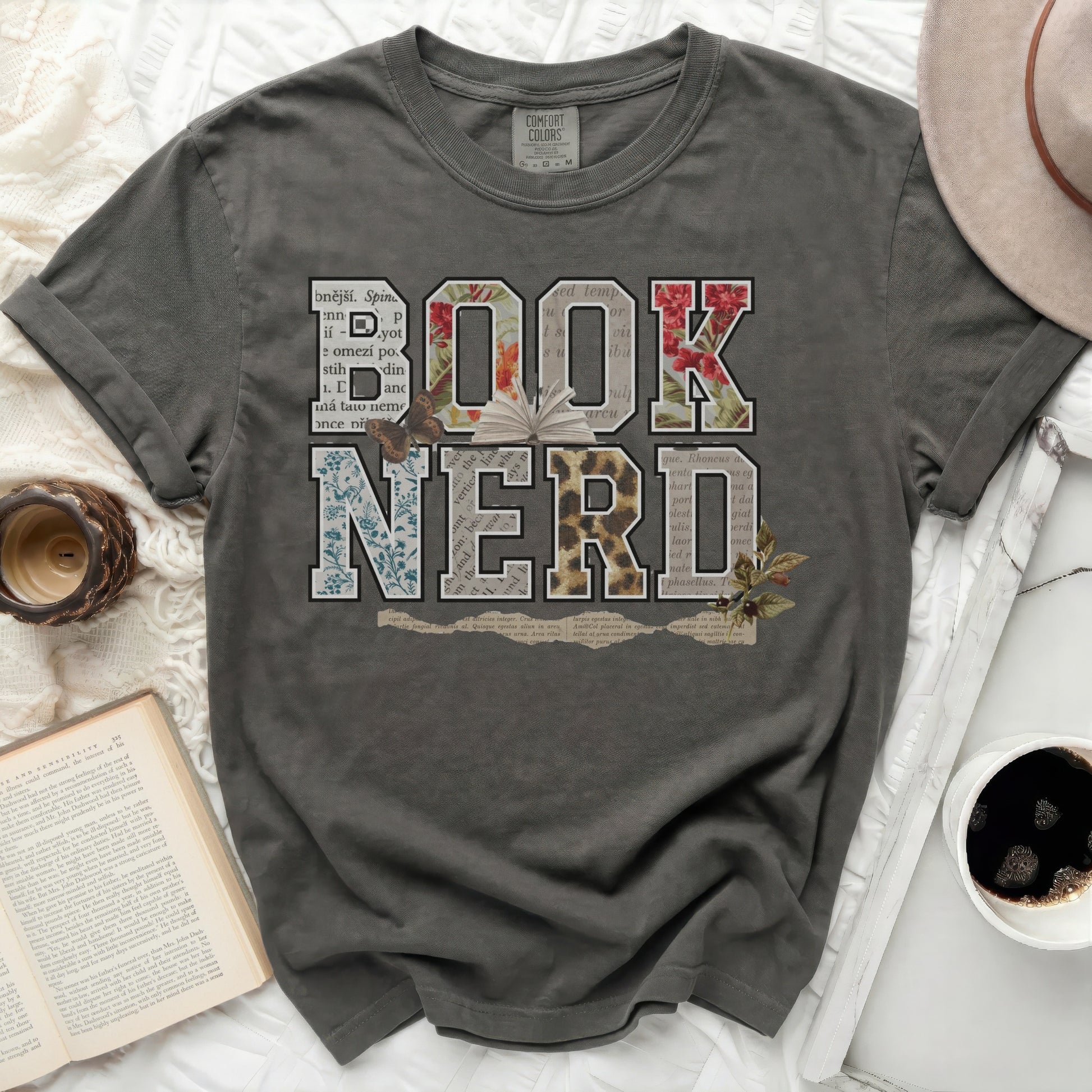 "Book Nerd" text with floral and vintage book page accents on a t-shirt.