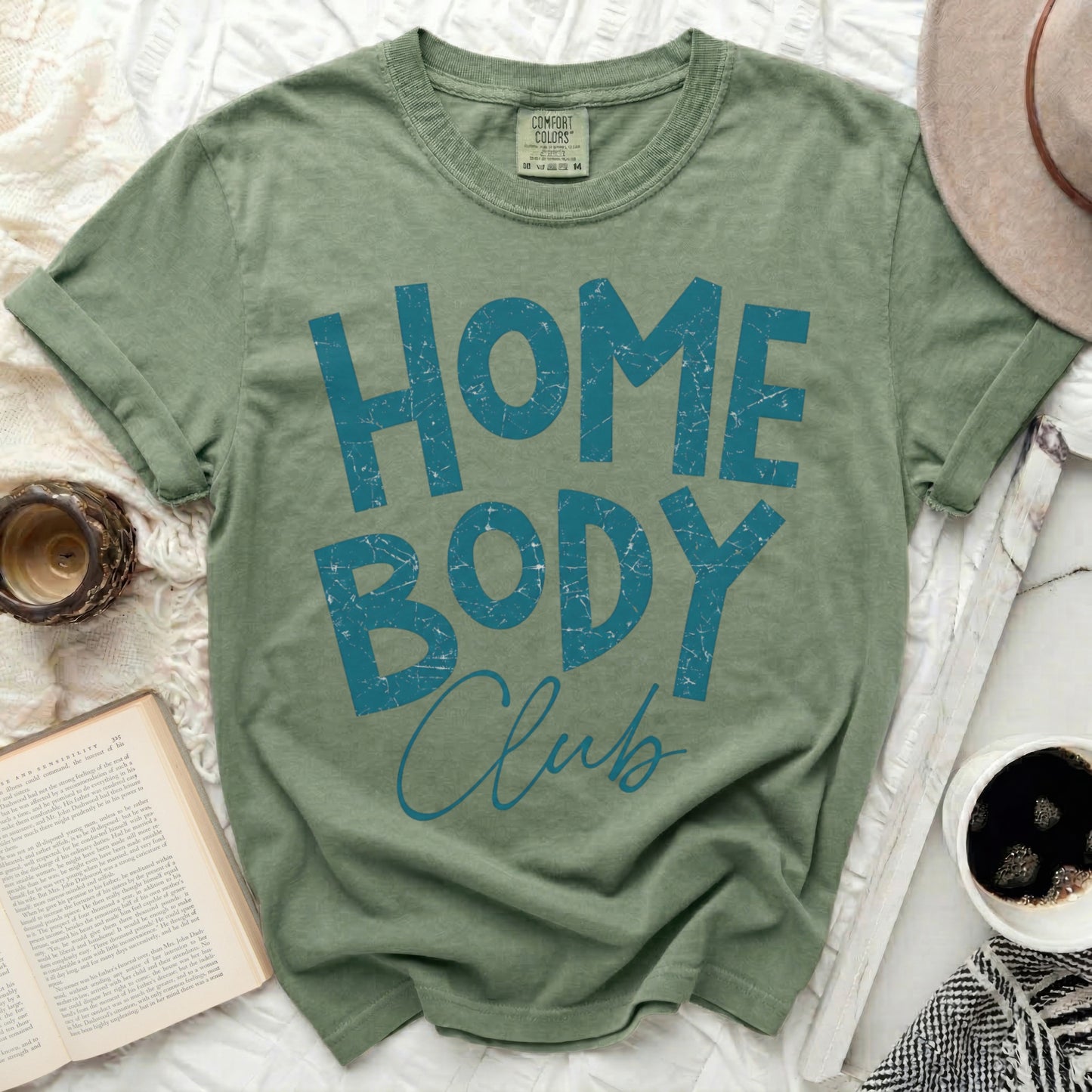 Green t-shirt with "HOME BODY Club" in distressed blue text.