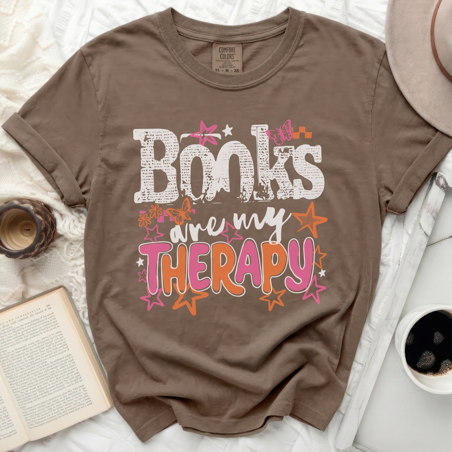Brown t-shirt with "Books are my THERAPY" graphic and floral designs.