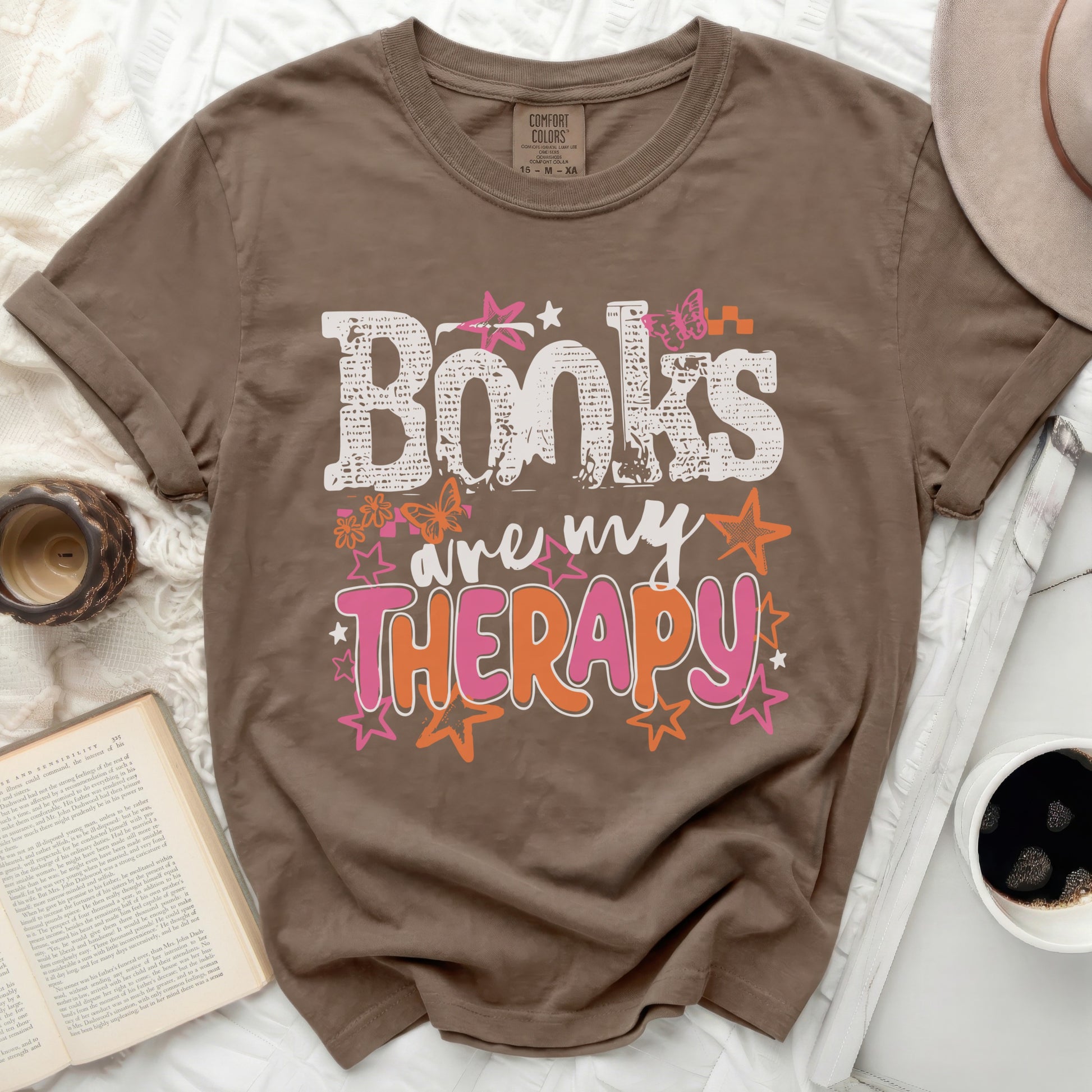 Brown t-shirt with "Books are my THERAPY" graphic and floral designs.