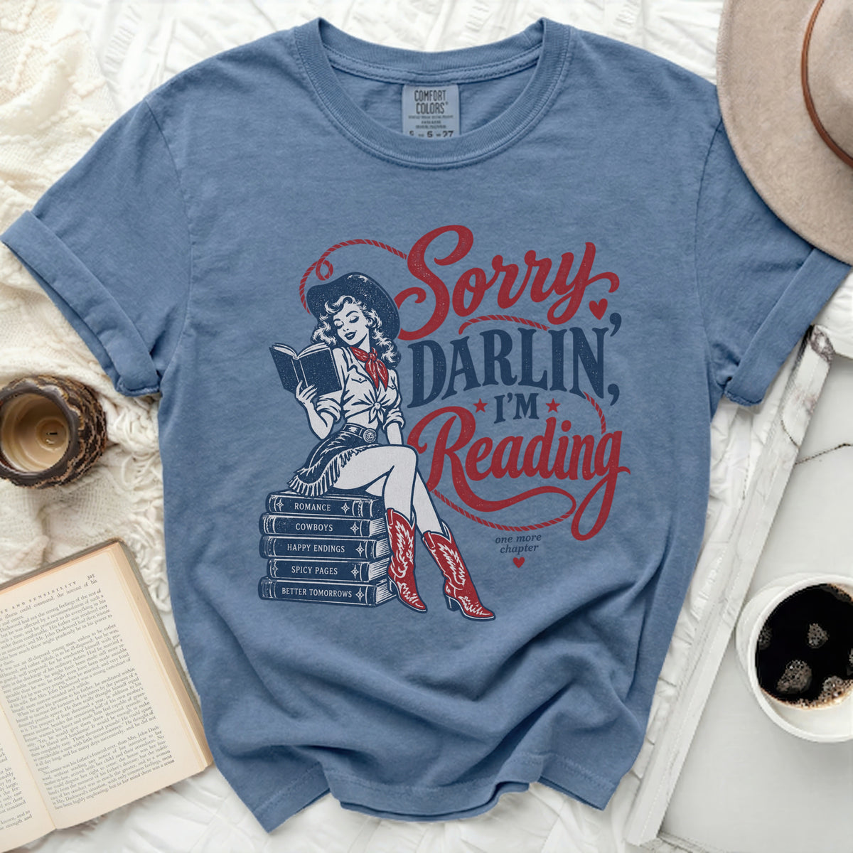 Blue t-shirt with "Sorry Darlin, I'm Reading" text and cowgirl graphic.