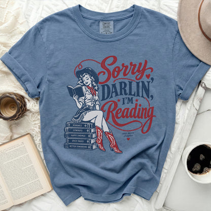 Blue t-shirt with "Sorry Darlin, I'm Reading" text and cowgirl graphic.