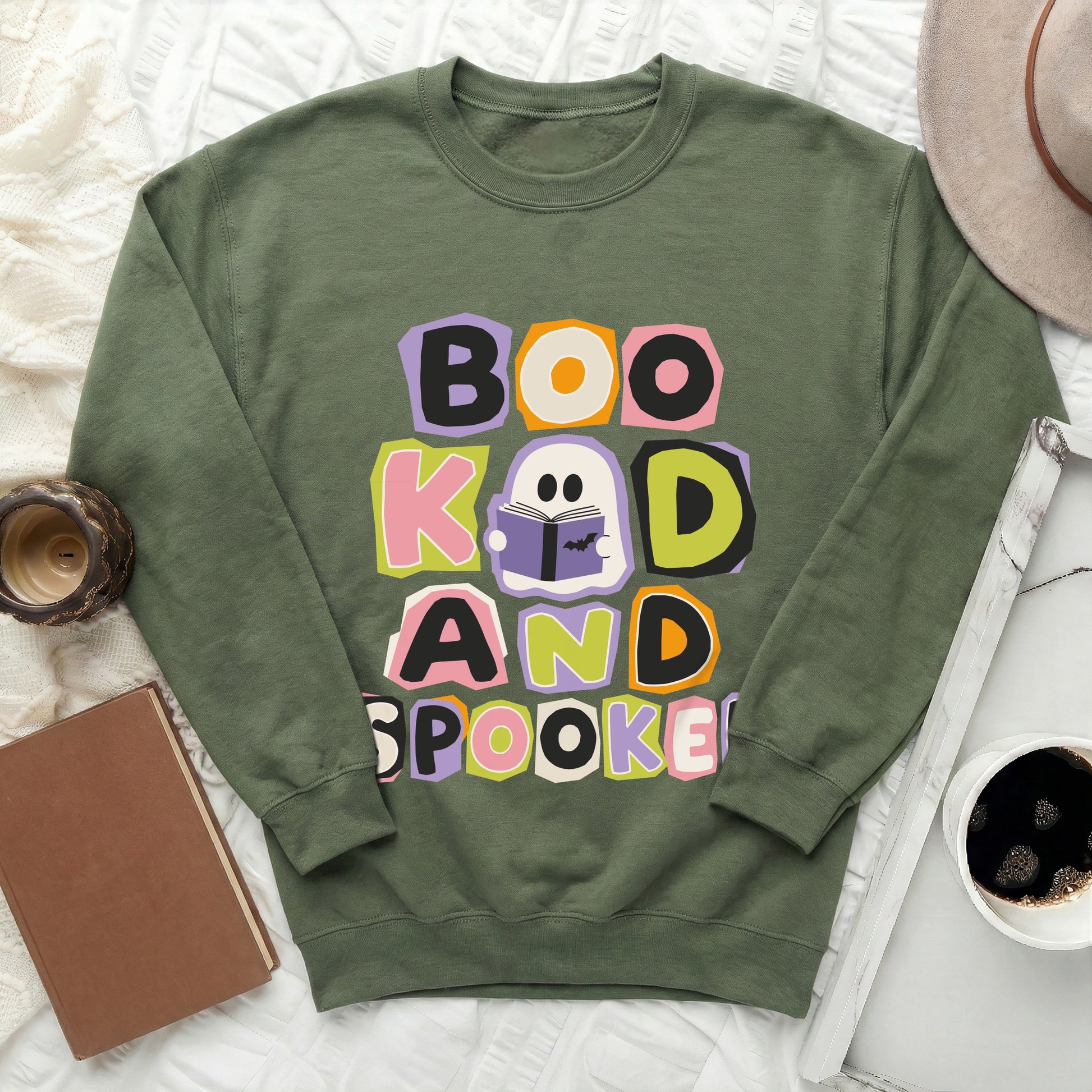 Green crewneck sweatshirt with "Boo, Kook, and Spooked" text and ghost graphic.