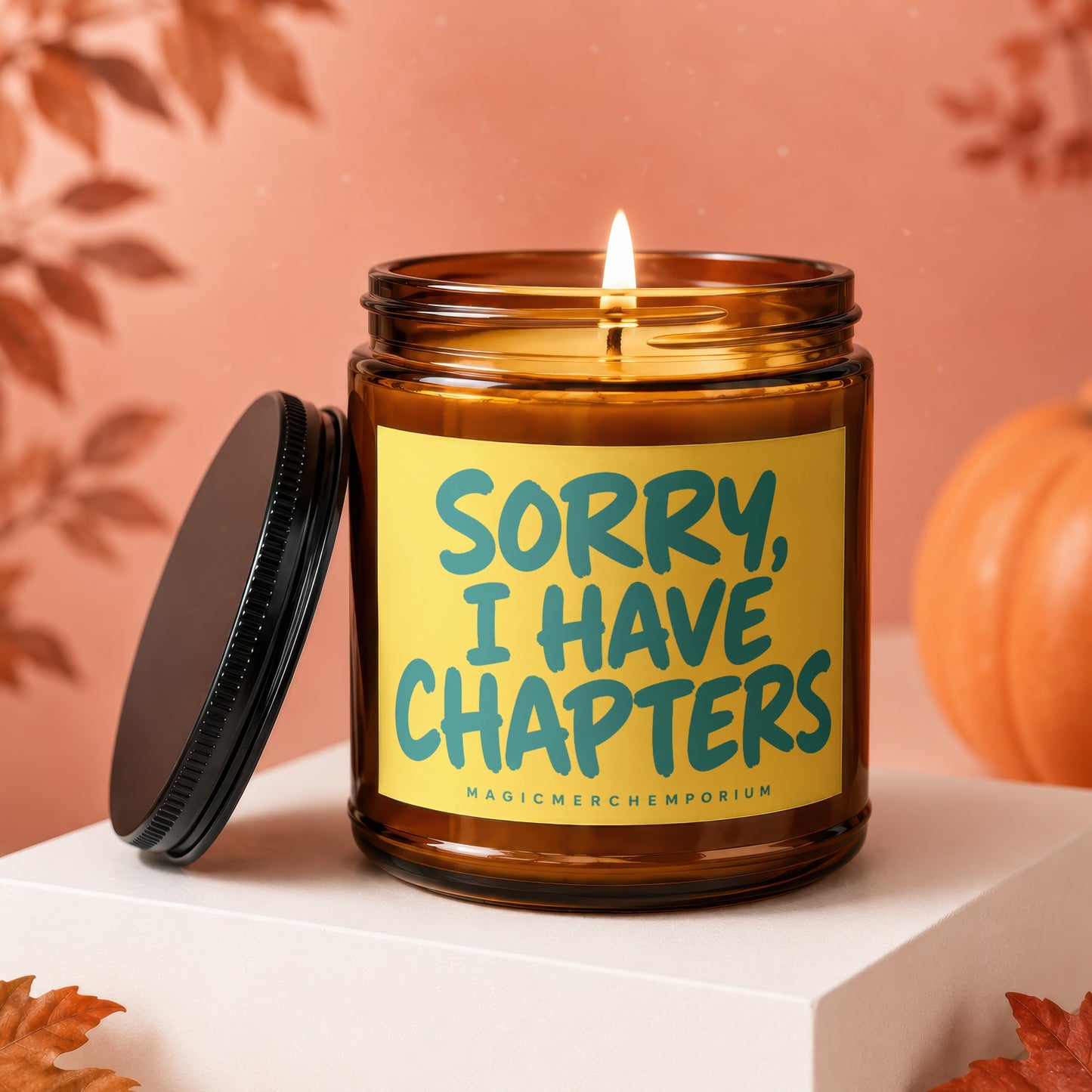 Brown glass candle with lit wick and yellow label saying "SORRY, I HAVE CHAPTERS".