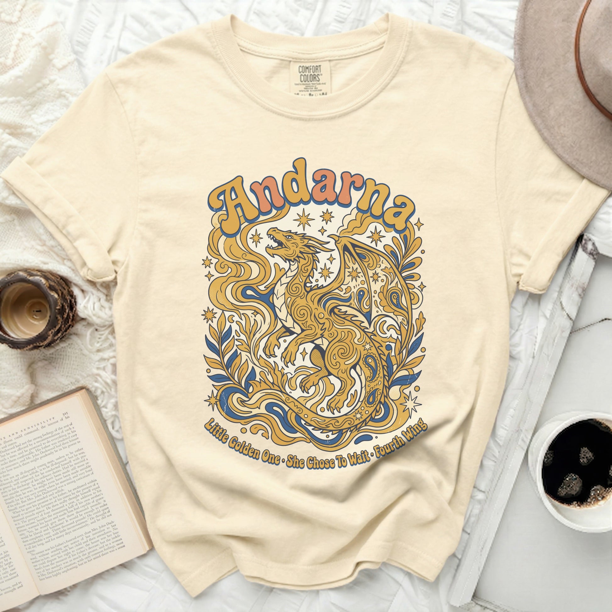 Cream t-shirt with gold dragon graphic and "Andarna Little Golden One • She Chose To Wait Fourth Wing" text.