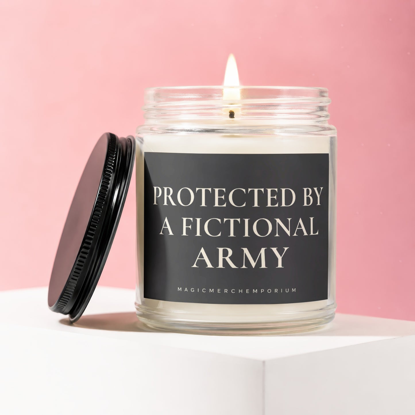 Glass jar candle with lit wick, black label reads "PROTECTED BY A FICTIONAL ARMY".