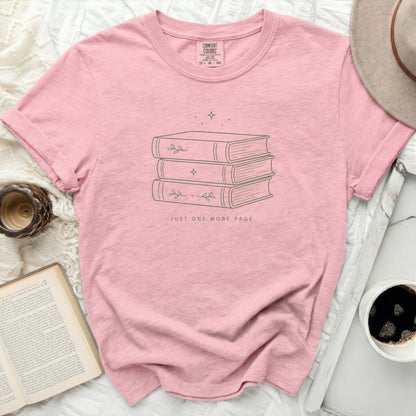 Pink t-shirt with stacked books and text "JUST ONE MORE PAGE."