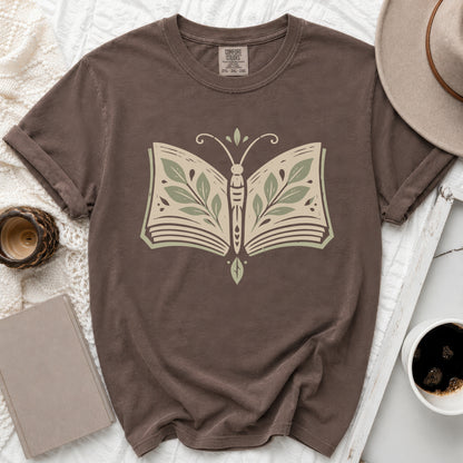 Brown t-shirt with a butterfly made of an open book with green leaves.