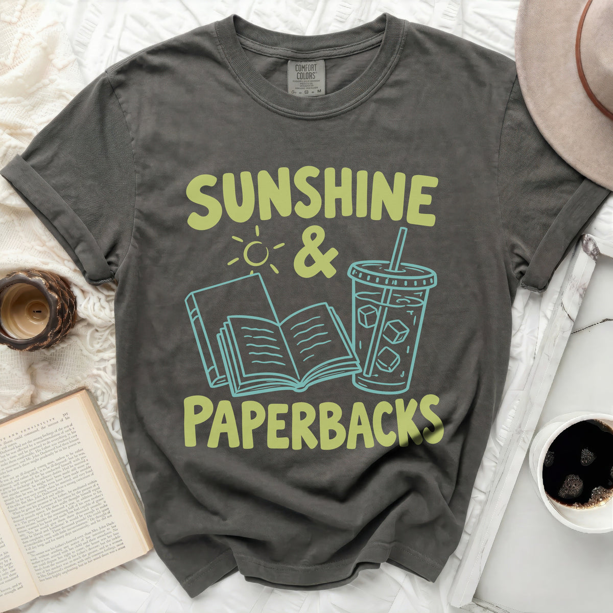 Dark gray t-shirt with "Sunshine & Paperbacks" graphic featuring an open book and iced drink.