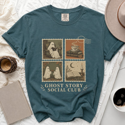Teal t-shirt with "Ghost Story Social Club" text and four postage stamp-style illustrations of ghosts.