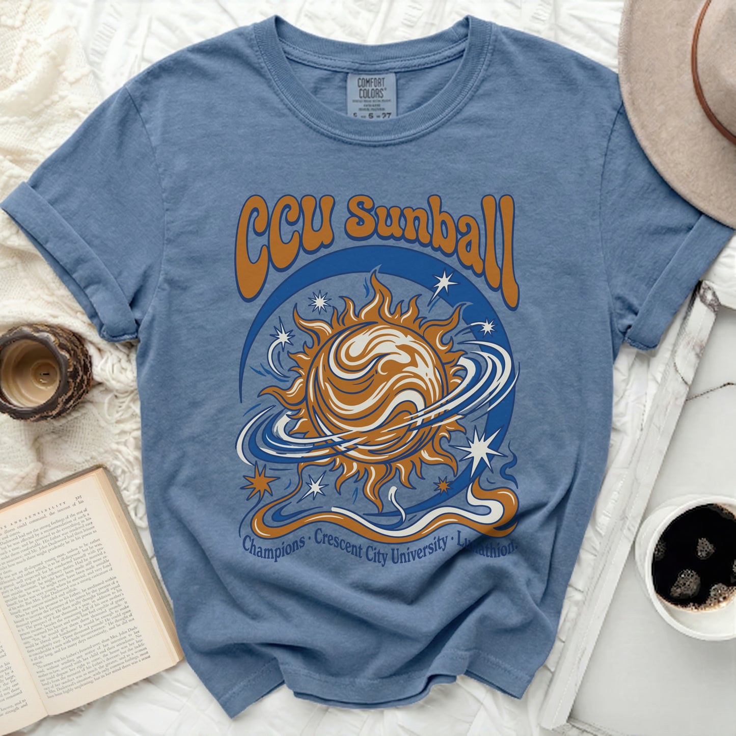 Blue t-shirt with "CCU Sunball Champions Crescent City University" text and sun graphic.