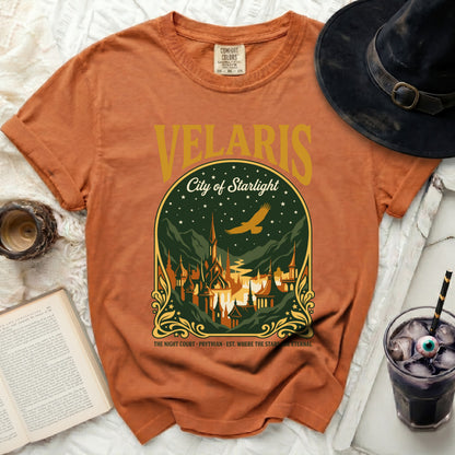 Orange t-shirt with "Velaris City of Starlight" graphic and witch hat.