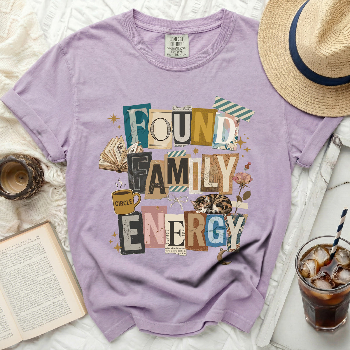 Found Family Energy graphic tee with books, cat, coffee cup and flowers.
