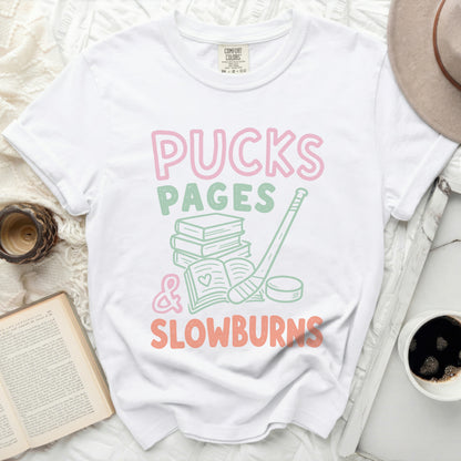 White t-shirt with "Pucks Pages & Slowburns" in pink and green.