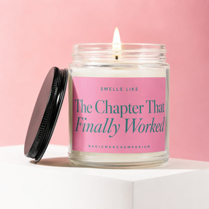 Jar candle with a lit wick and pink label that reads "Smells Like The Chapter That Finally Worked".