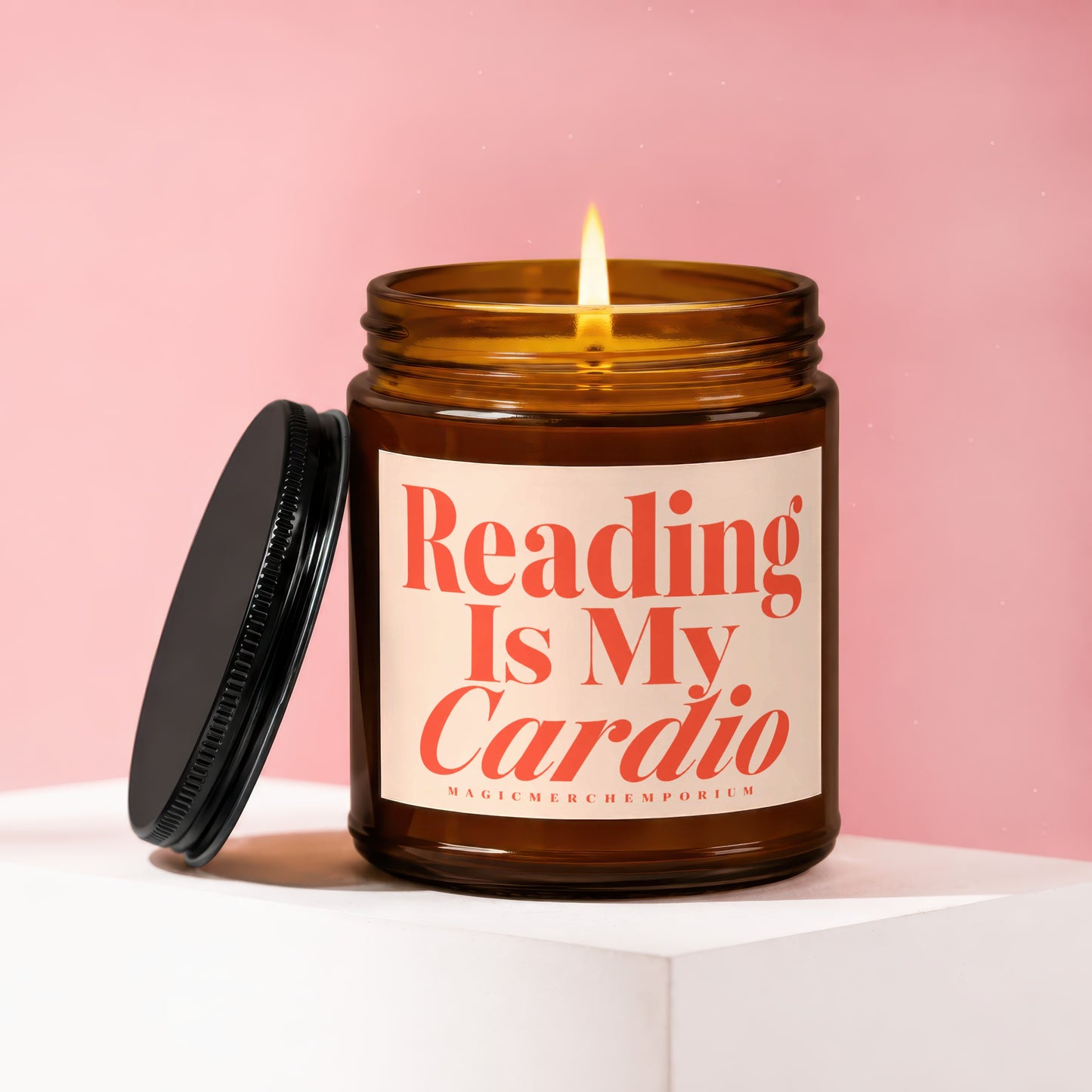 Amber jar candle with lit flame, reads "Reading Is My Cardio."