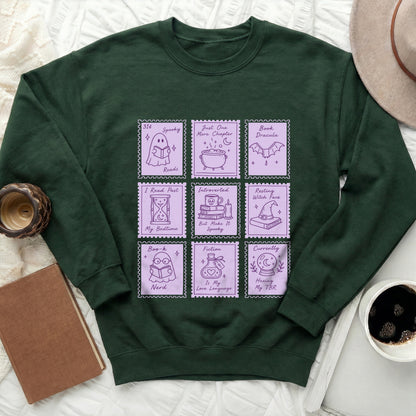 Dark green sweatshirt with purple stamp graphics about reading and spooky themes.