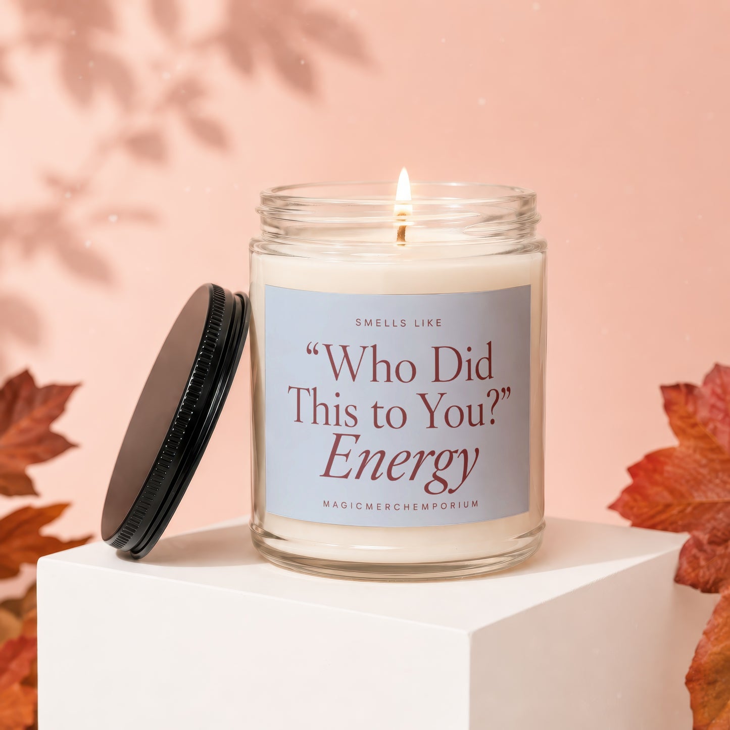 Lit candle in jar with label text "Who Did This to You?" Energy.