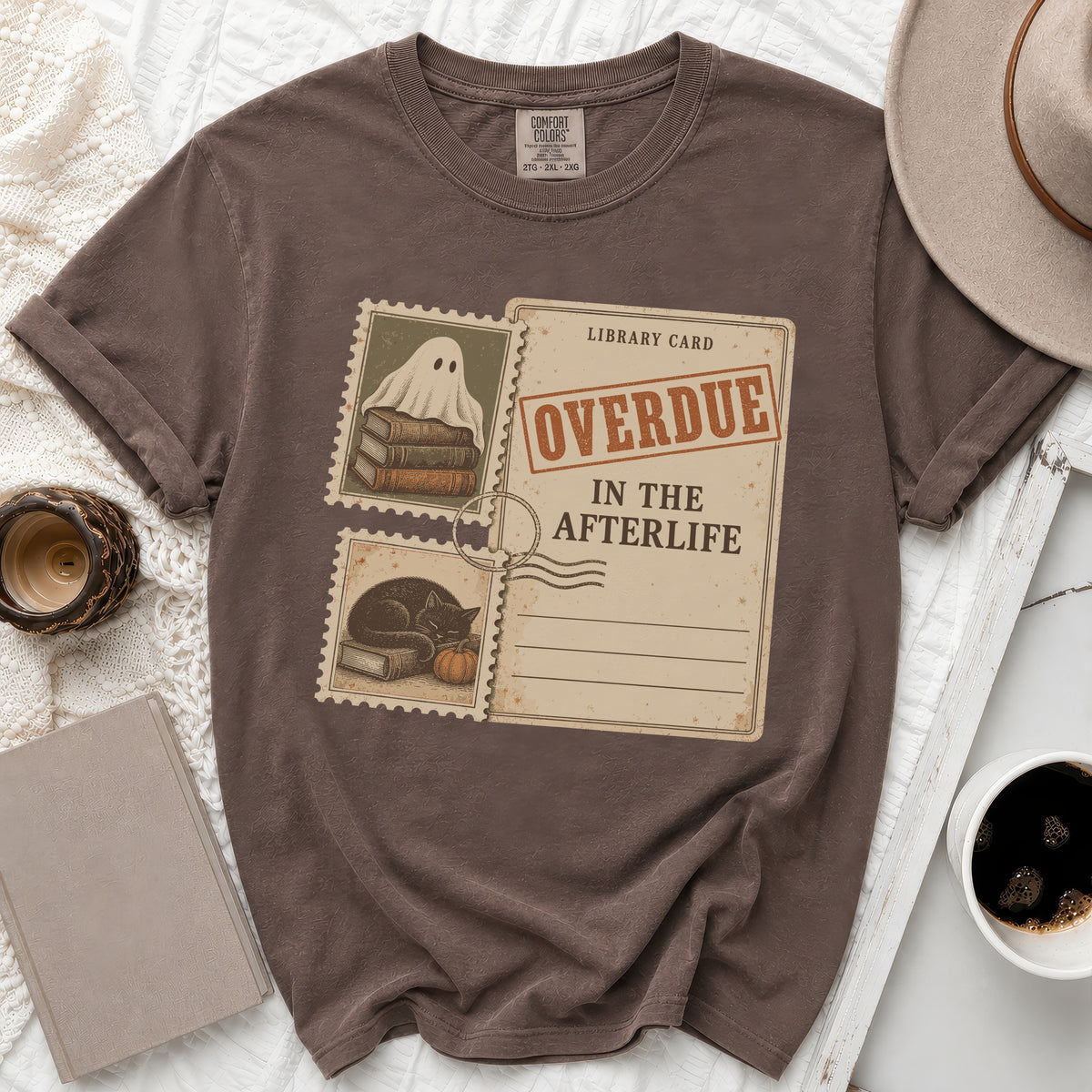 Brown t-shirt with "Overdue In The Afterlife" library card graphic and postage stamps.
