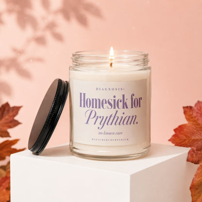 A lit candle in a glass jar with a black lid, resting on a white block against a peach background.