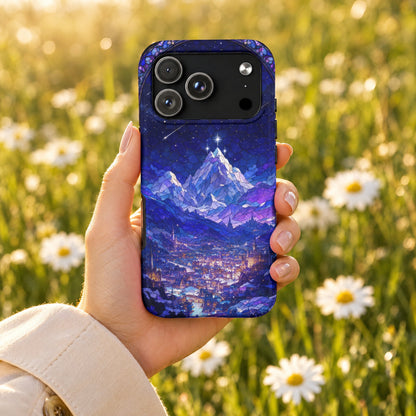 A hand holds a smartphone with a blue stained-glass mountain landscape case against a blurred daisy field.