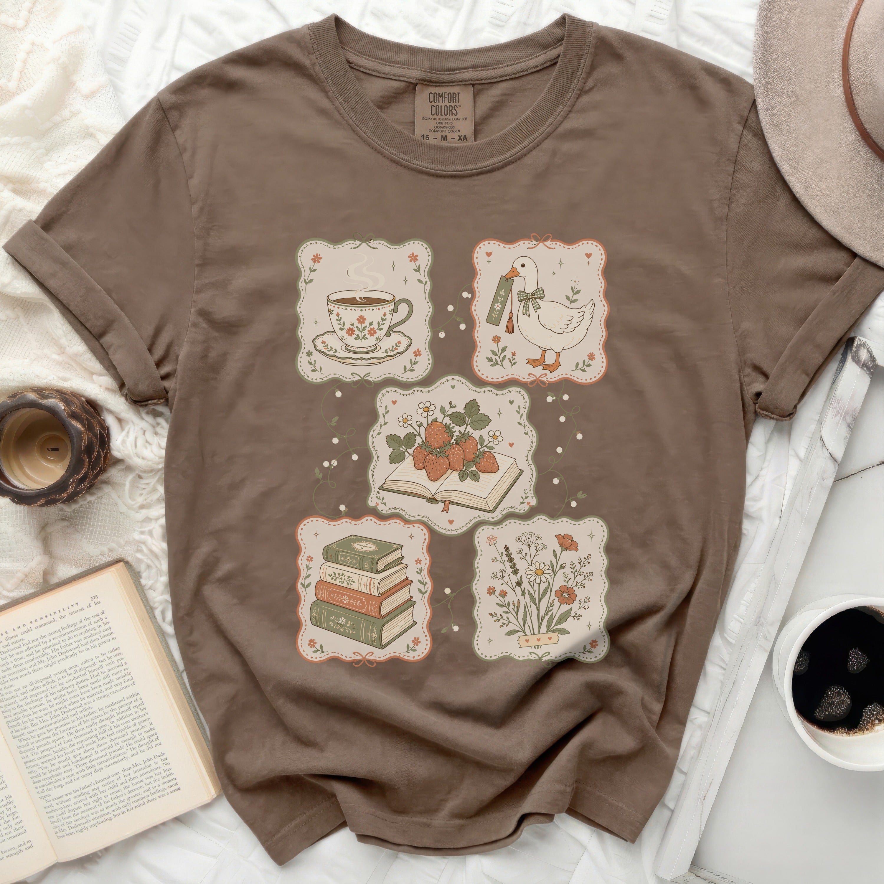 Brown t-shirt with framed illustrations of tea, books, strawberries, and a duck.