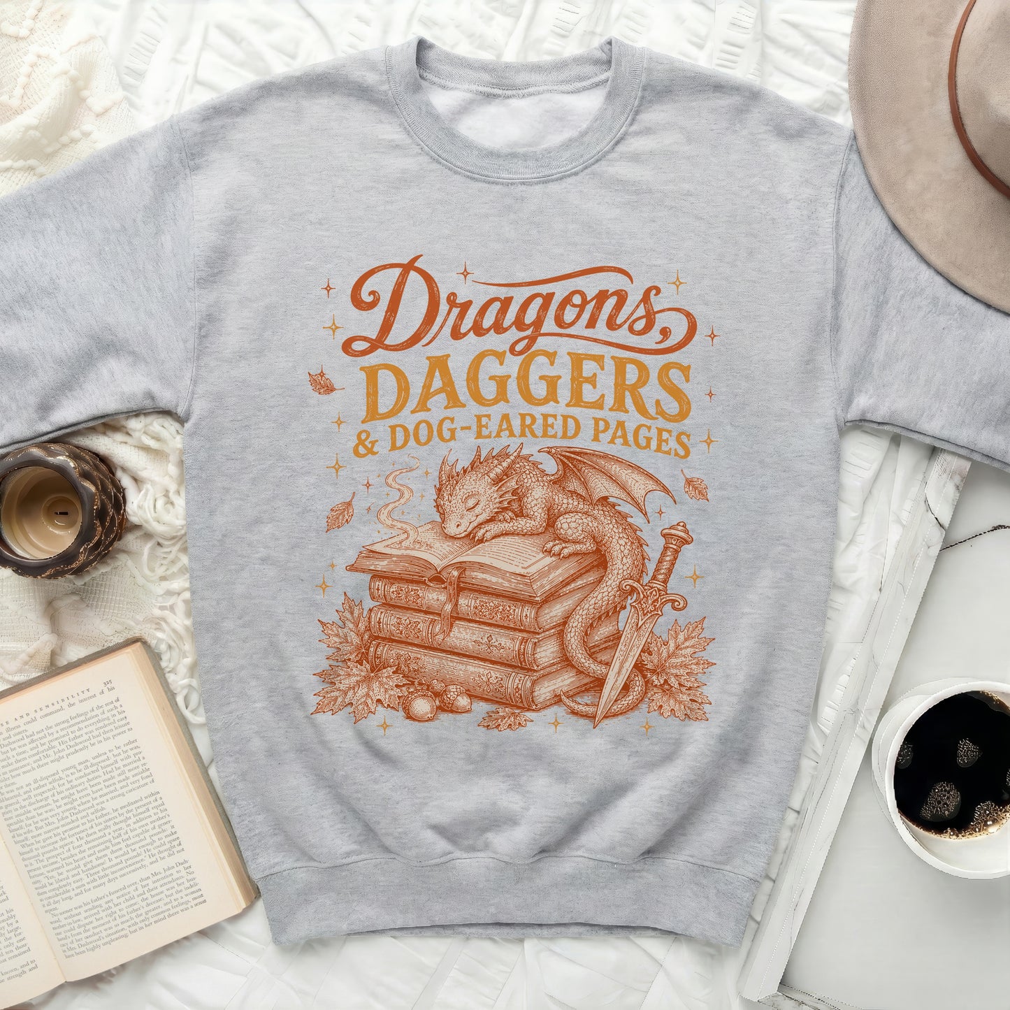 Grey sweatshirt with "Dragons, Daggers & Dog-Eared Pages" graphic.