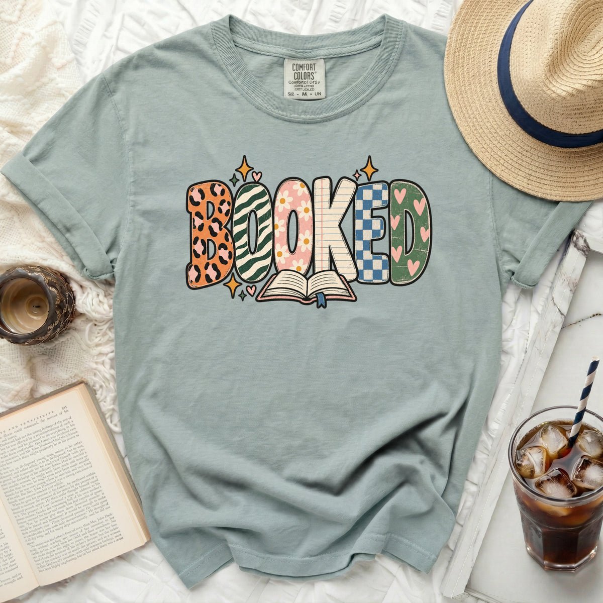 Green t-shirt with "BOOKED" graphic and an open book.