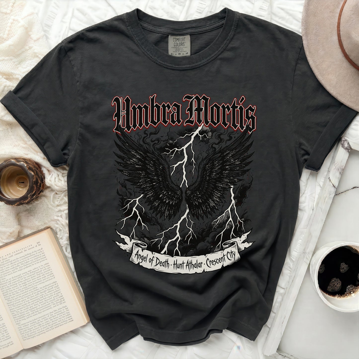 Black t-shirt with "Umbra Mortis" and angel wings graphic.