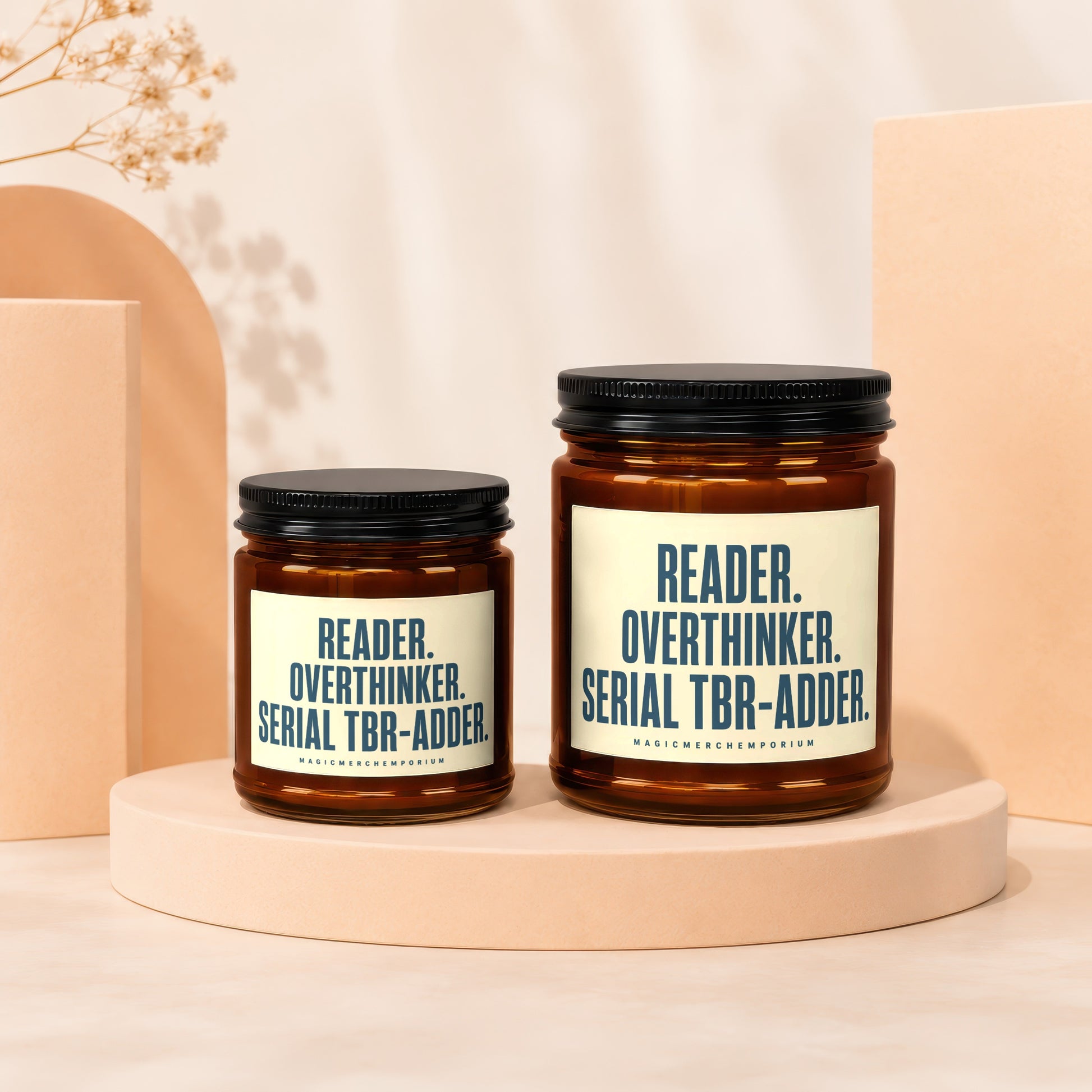 Two candles with text "READER. OVERTHINKER. SERIAL TBR-ADDER." and "MAGICMERCHEMPORIUM".