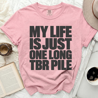 Pink t-shirt with black text "MY LIFE IS JUST ONE LONG TBR PILE".