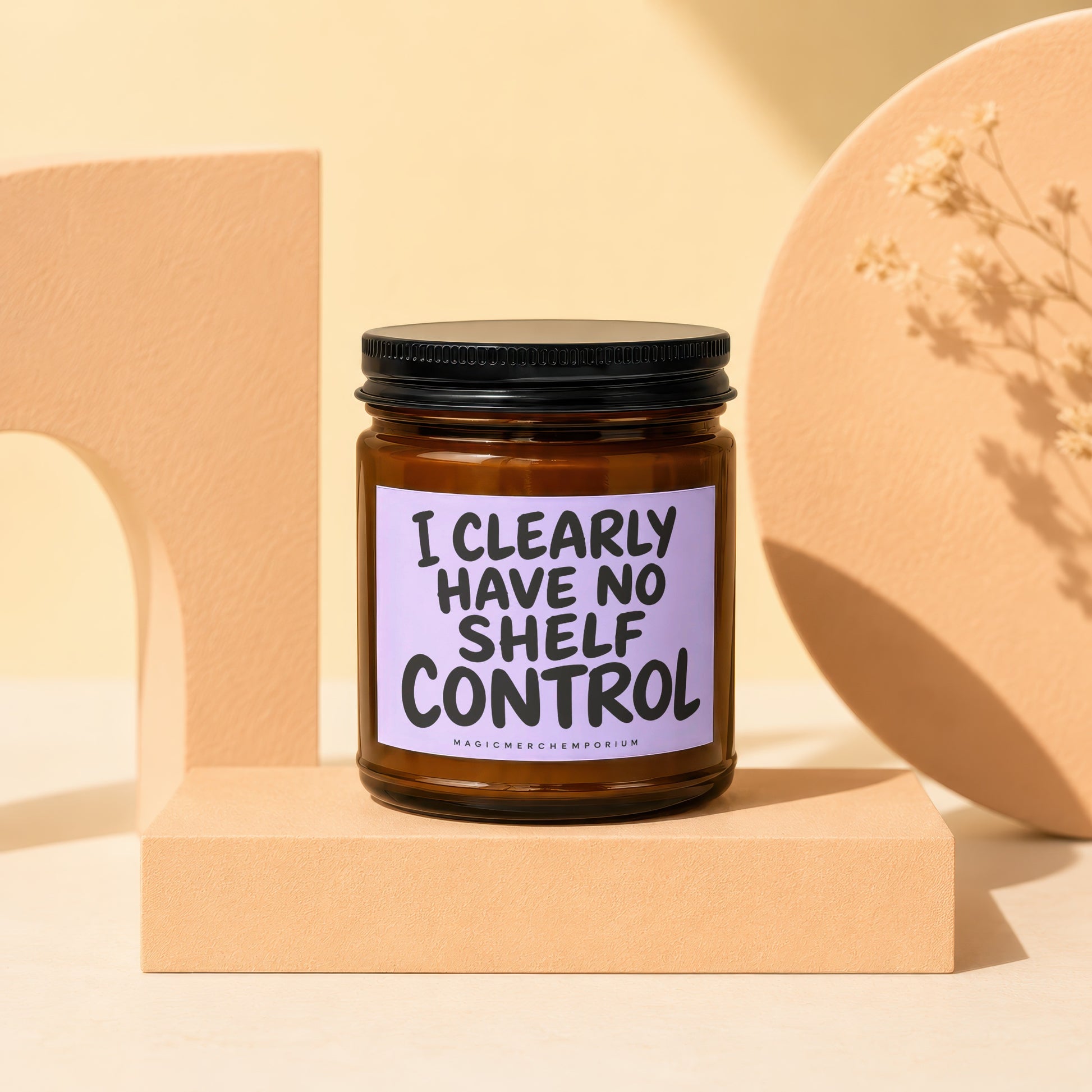 Candle with text "I CLEARLY HAVE NO SHELF CONTROL" on a light purple label.