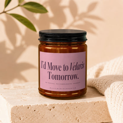 Amber jar candle with pink label reading "I'd Move to Velaris Tomorrow."