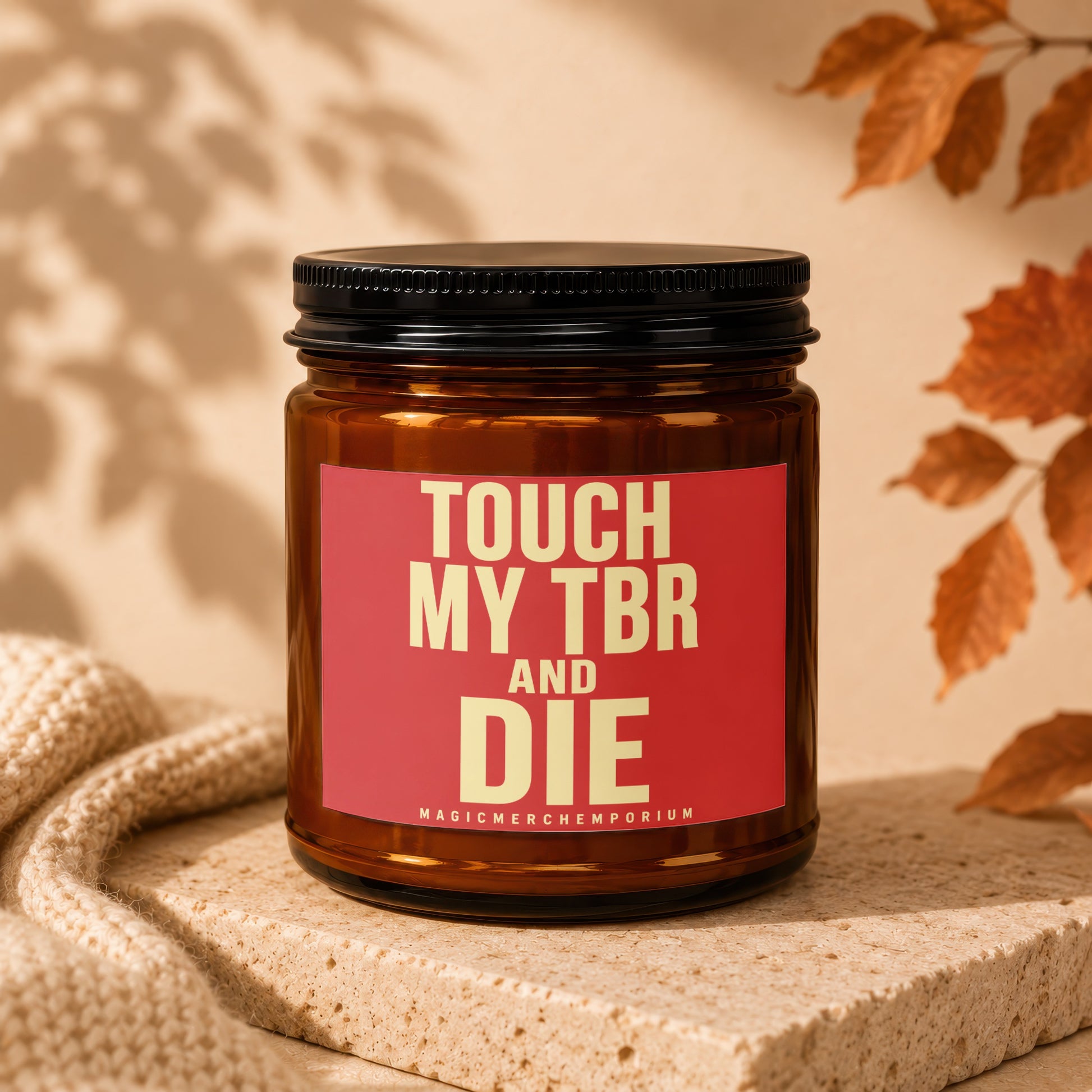 Amber jar candle with red label that reads "TOUCH MY TBR AND DIE MAGICMERCHMMPORIUM"