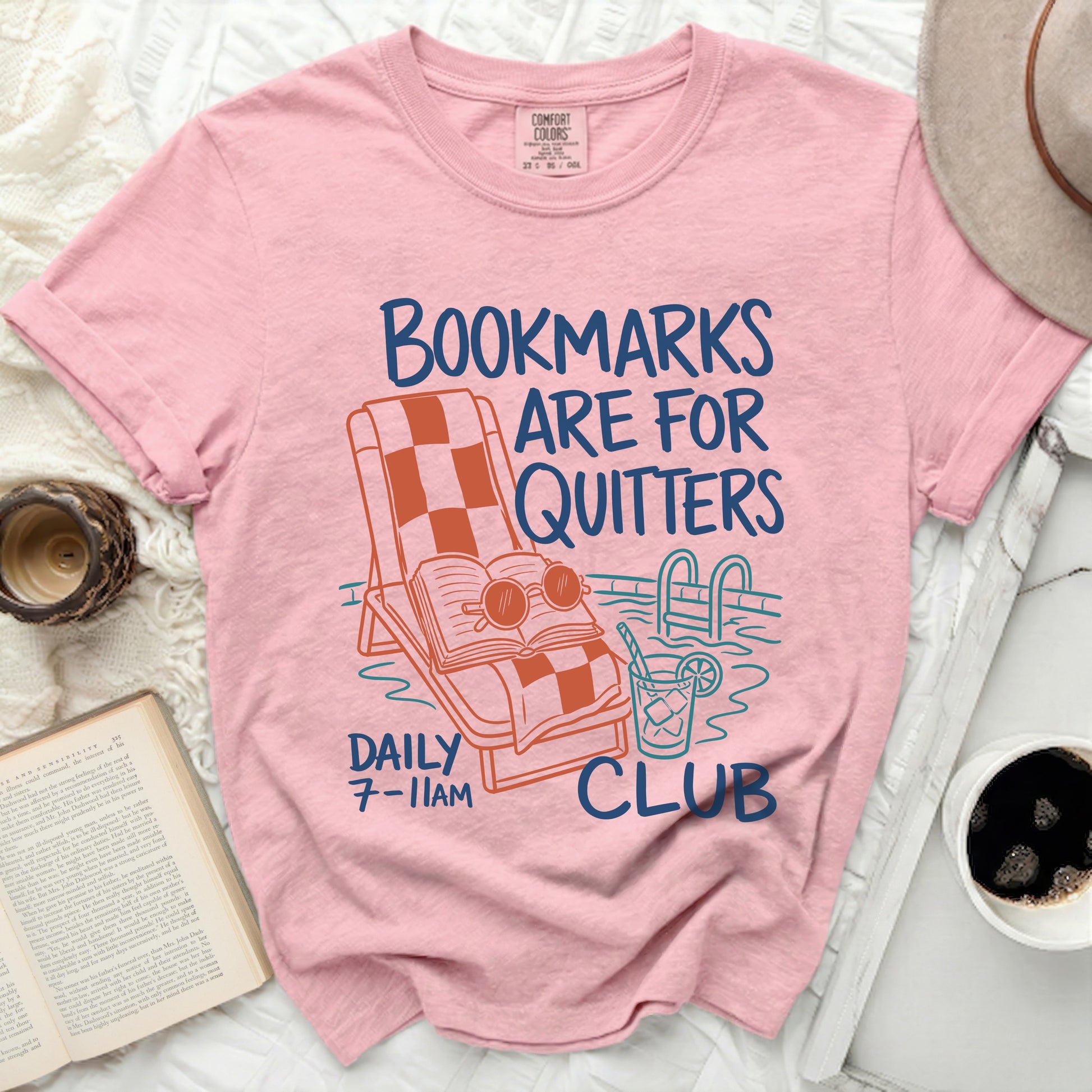 Pink t-shirt with "Bookmarks are for quitters club" text and graphic.