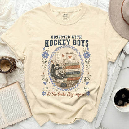 Cream t-shirt with "Obsessed with Hockey Boys & the books they inspire" text and stack of books.