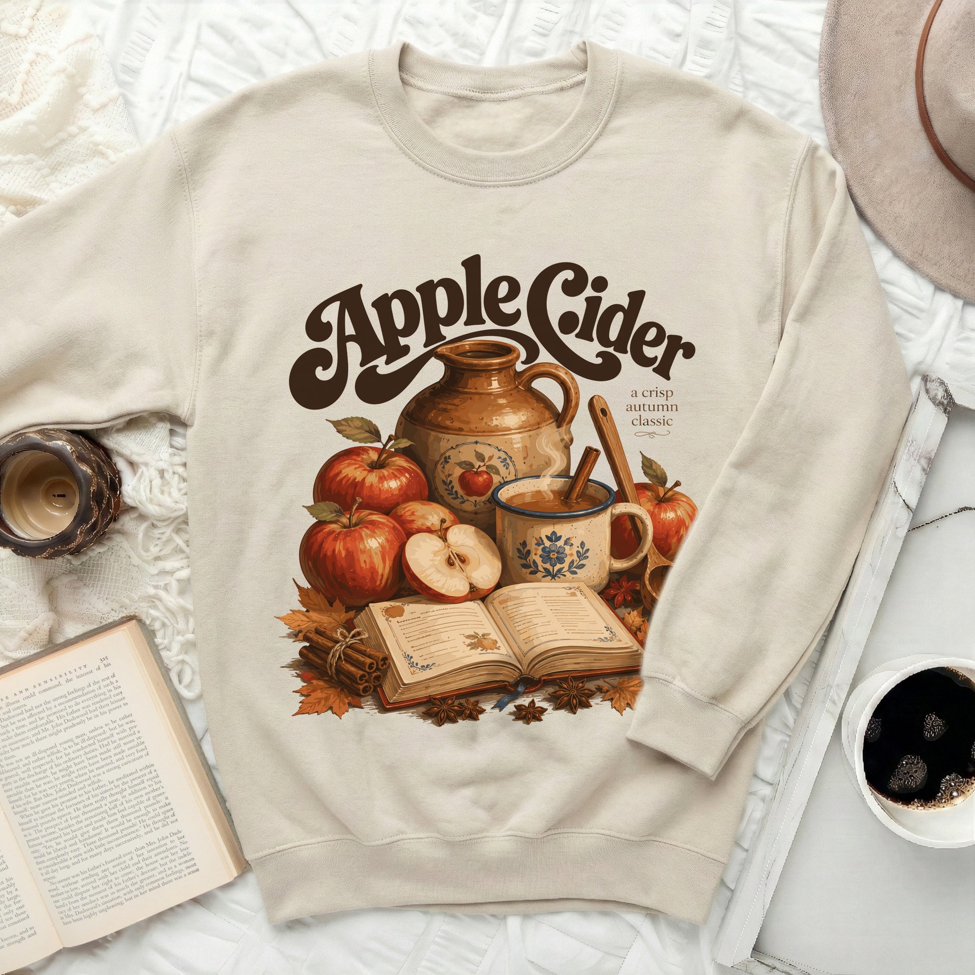 Cream sweatshirt with "Apple Cider a crisp autumn classic" graphic.