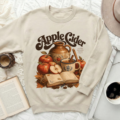 Cream sweatshirt with "Apple Cider a crisp autumn classic" graphic.